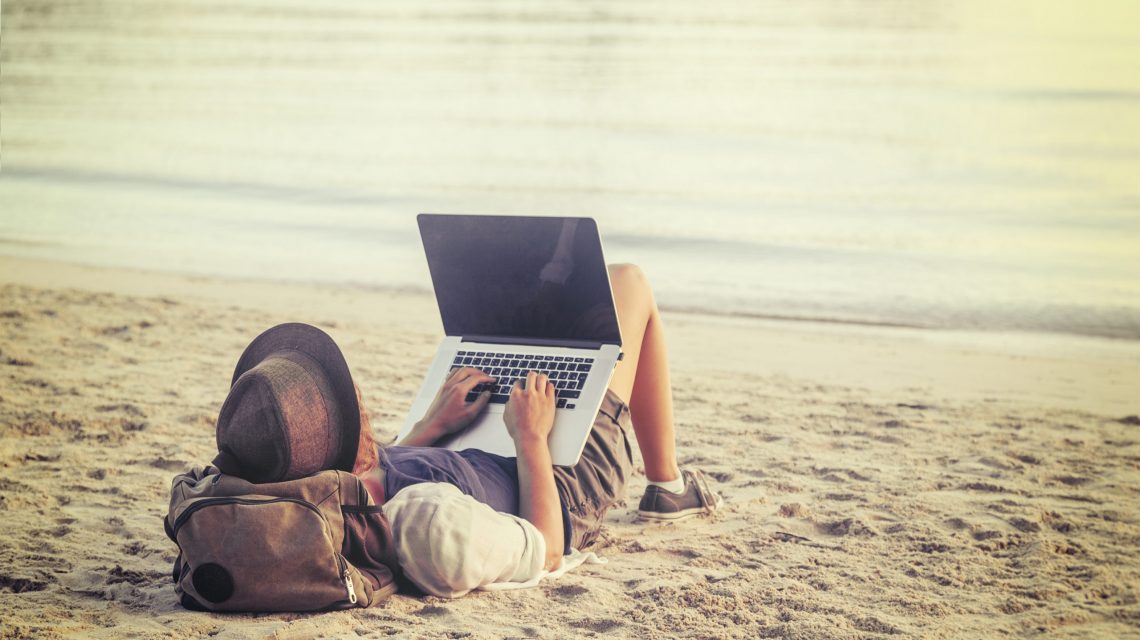 Young,Woman,Using,Laptop,Computer,On,A,Beach.,Freelance,Work